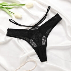 Black lace lingerie set on a white fabric background with tulips.