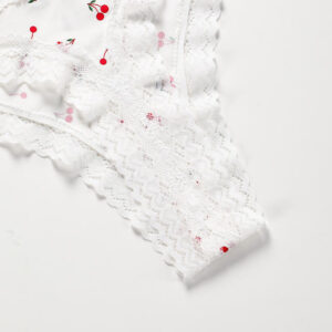 White textured fabric with red and pink floral patterns on a light gray background