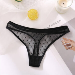 Black mesh thong on a white surface with a lemon and magazine in the background