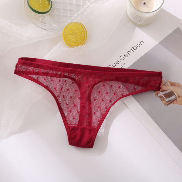 Red lace thong on a magazine with lemon slices and a candle in the background